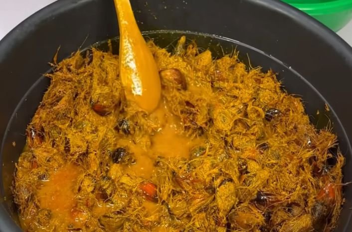 A bowl of boiled and shredded palm fruits ready be processed to get crude palm oil